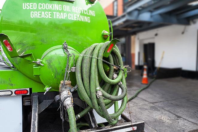 a technician pumping a grease trap in a commercial building in Jacksonville